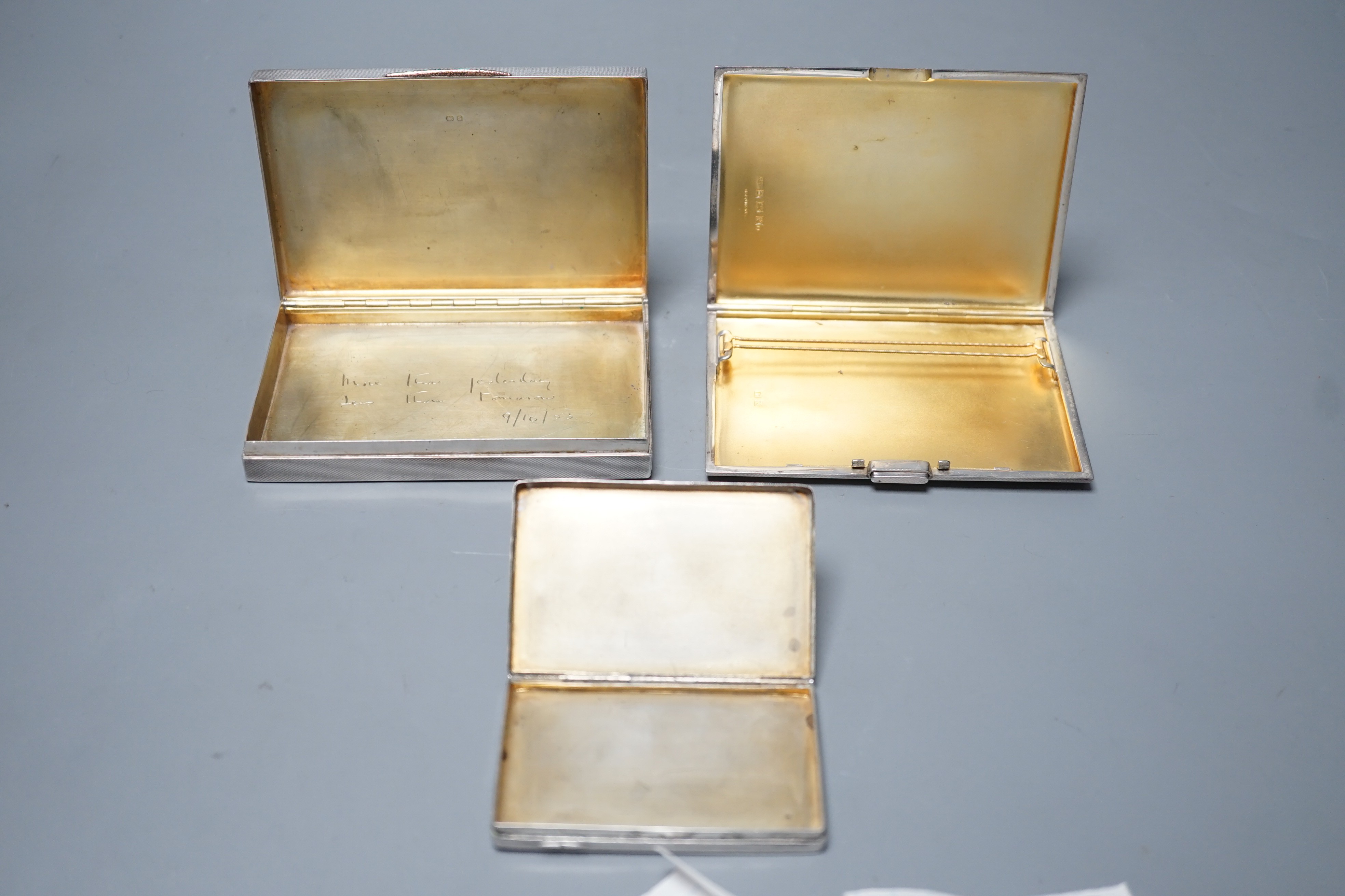 A George VI engine turned silver rectangular cigarette box/case, engraved with a squirrel, W.H. Manton Ltd, Birmingham, 1942, 12.2cm, one other Mappin & Webb silver cigarette case and a continental white metal snuff box.